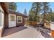 Back deck features wood deck, a BBQ, and surrounding trees for privacy at 10179 S Turkey Creek Rd, Morrison, CO 80465