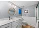 Bathroom featuring marble vanity, round mirror, updated lighting, and wood-look floor at 10179 S Turkey Creek Rd, Morrison, CO 80465