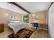 Bedroom with wood floors, decorative rug, wood beam, and desk area at 10179 S Turkey Creek Rd, Morrison, CO 80465