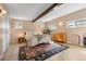 Bedroom with wood floors, decorative rug, wood beam, and bright windows at 10179 S Turkey Creek Rd, Morrison, CO 80465