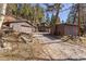 Exterior view of home with driveway, garage and sheds surrounded by trees at 10179 S Turkey Creek Rd, Morrison, CO 80465