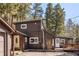 Exterior elevation showcasing brown siding, dual entryways and decks with surrounding trees at 10179 S Turkey Creek Rd, Morrison, CO 80465