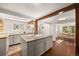 Bright kitchen featuring a center island, wooden beam, and natural light from a large window, seamlessly connecting to the dining area at 10179 S Turkey Creek Rd, Morrison, CO 80465