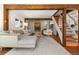 Sunlit living room with wood beams, stairs, and a comfortable sofa creates an inviting space at 10179 S Turkey Creek Rd, Morrison, CO 80465