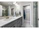 Bathroom with double sinks, vanity, and a separate glass-enclosed shower at 4581 S Kipling Cir, Denver, CO 80123