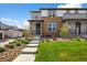 Charming two-story home with brick and gray siding, a landscaped yard, and a welcoming front porch at 4581 S Kipling Cir, Denver, CO 80123