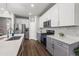 Modern kitchen featuring stainless steel appliances, gray cabinets, and quartz countertops at 4581 S Kipling Cir, Denver, CO 80123