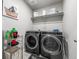 Modern laundry room equipped with front-load washer and dryer, storage shelves, and tidy organization at 4581 S Kipling Cir, Denver, CO 80123