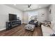 Bright living room featuring a ceiling fan, TV, and comfortable seating near a large window at 4581 S Kipling Cir, Denver, CO 80123