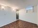 This basement features a textured wall, brick flooring, and small window for natural light at 3531 E 91St Ave, Thornton, CO 80229