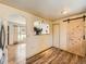 Dining area with hardwood flooring, barn-style door and connecting archway to kitchen at 3531 E 91St Ave, Thornton, CO 80229