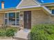 Close-up of the front entrance, showcasing a brick facade, a decorative storm door, and lush shrubbery at 3531 E 91St Ave, Thornton, CO 80229