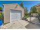 This garage features a large, white garage door, siding, and a fenced backyard at 3531 E 91St Ave, Thornton, CO 80229