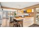 Bright kitchen boasts light wood cabinets, stainless appliances, and a stylish breakfast bar island at 3270 S Washington St, Englewood, CO 80113