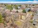 Expansive aerial view showcases a yellow home nestled among mature trees in a neighborhood with mountain views in the distance at 10627 Chautauga Mtn, Littleton, CO 80127