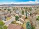 Scenic aerial view of a suburban neighborhood featuring a yellow home and stunning mountain range in the background at 10627 Chautauga Mtn, Littleton, CO 80127