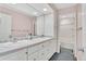 Bathroom featuring a double vanity with ample storage, large mirrors, and a view into the shower area at 10627 Chautauga Mtn, Littleton, CO 80127