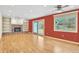 Cozy living room with a brick fireplace, built-in shelving, hardwood floors and natural light from an outdoor sliding door at 10627 Chautauga Mtn, Littleton, CO 80127