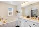 Elegant bathroom featuring double sinks, stylish fixtures, and a soaking tub at 8437 Mount Kataka Loop, Littleton, CO 80125