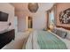 Well-lit bedroom featuring a bathroom, wooden bed frame, bedside tables, and stylish decor at 8437 Mount Kataka Loop, Littleton, CO 80125