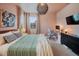 This bedroom has large windows, stylish lighting, a comfortable bed, a desk, and closet space at 8437 Mount Kataka Loop, Littleton, CO 80125