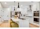 Modern kitchen features white cabinets, stainless steel appliances, island with seating and stylish pendant lights at 8437 Mount Kataka Loop, Littleton, CO 80125
