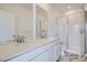 Bathroom featuring double sink vanity, large mirror, and walk-in shower at 8887 San Antonio St, Littleton, CO 80125