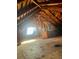 Spacious attic with exposed wooden beams and natural light from a window at 241 W 4Th Ave, Denver, CO 80223