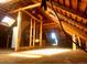 Exposed rafters and abundant sunlight fill the attic space, highlighting its potential for renovation at 241 W 4Th Ave, Denver, CO 80223