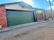 A detached garage with a green door, basketball hoop, and a mix of brick and siding exterior at 241 W 4Th Ave, Denver, CO 80223