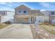 Two-story home featuring an attached garage, cozy front porch, and well-manicured lawn in a friendly neighborhood at 5214 Perth Ct, Denver, CO 80249