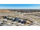 Aerial view of modern homes with sidewalks, well-maintained landscaping, and nearby undeveloped land at 6812 Indian Paintbrush St, Frederick, CO 80530
