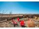 Landscaped backyard with rock groundcover, an outdoor firepit, and red Adirondack chairs at 6812 Indian Paintbrush St, Frederick, CO 80530