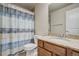 Bathroom with wood cabinet, granite countertop, toilet, and blue shower curtain at 6812 Indian Paintbrush St, Frederick, CO 80530