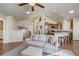 Inviting living room with hardwood floors, open layout, and a view of the modern kitchen at 6812 Indian Paintbrush St, Frederick, CO 80530