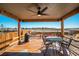 Covered wooden patio with a ceiling fan, string lights, grill and dining set at 6812 Indian Paintbrush St, Frederick, CO 80530