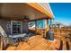 Inviting covered wooden patio with a grill and dining set at 6812 Indian Paintbrush St, Frederick, CO 80530