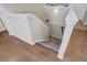 Staircase with carpeted steps transitioning from hardwood flooring, featuring white banisters at 6812 Indian Paintbrush St, Frederick, CO 80530
