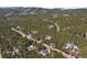 High aerial of a home's setting amidst a forest; perfect for nature enthusiasts and seclusion at 140 Beaver Rd, Idaho Springs, CO 80452