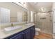 Modern bathroom with dual sinks, a large mirror, updated fixtures, and a tiled walk-in shower at 140 Beaver Rd, Idaho Springs, CO 80452