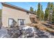 Exterior back of the house with a garage, snow, stairs, and surrounded by pine trees at 140 Beaver Rd, Idaho Springs, CO 80452