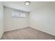 Clean bedroom with neutral carpet, fresh paint and a large window offering natural light at 7017 W 62Nd Pl, Arvada, CO 80003