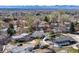Charming two-story home with a gray exterior, lush trees, and a view of the Denver city and mountains at 7017 W 62Nd Pl, Arvada, CO 80003