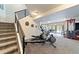 Basement stairs leading to a recreation space with exercise equipment and natural light at 445 Panoramic Dr, Monument, CO 80132