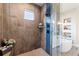 Modern shower with tile surround, bench, and glass door at 445 Panoramic Dr, Monument, CO 80132