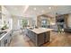 Open-concept kitchen flows into the living room, featuring a large island, modern appliances, and a cozy fireplace at 445 Panoramic Dr, Monument, CO 80132