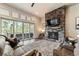 Cozy living room with a stone fireplace, large windows, and comfortable seating for relaxing and entertaining at 445 Panoramic Dr, Monument, CO 80132