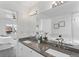 Bathroom featuring a double sink, granite countertop, large mirror and soaking tub in the background at 152 S Jackson St, Denver, CO 80209