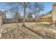 Spacious backyard featuring mature trees, a wooden fence, and a covered patio, perfect for outdoor activities at 1348 E Jamison Ave, Centennial, CO 80122
