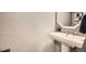 Bright bathroom featuring pedestal sink, modern fixtures, and textured walls at 1348 E Jamison Ave, Centennial, CO 80122